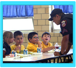 A police officer speaks with school children